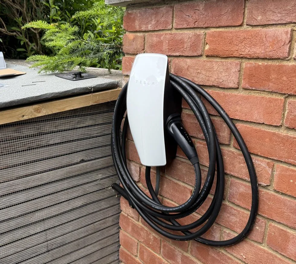 Tesla Wall Connector en el jardín de una vivienda